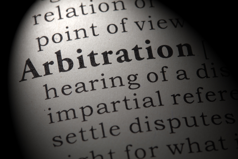 image shows dictionary page with definition of  arbitration on it. 