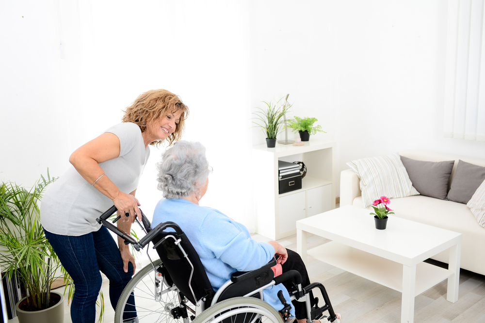 Cheerful,Mature,Woman,Visiting,Retirement,Home,Residence,With,Elderly,Senior image shows elderly woman in wheel chair